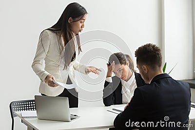 Angry asian executive shouting at subordinates scolding for bad Stock Photo