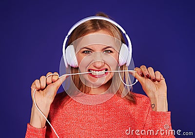 Angry blond in headphones biting cord Stock Photo