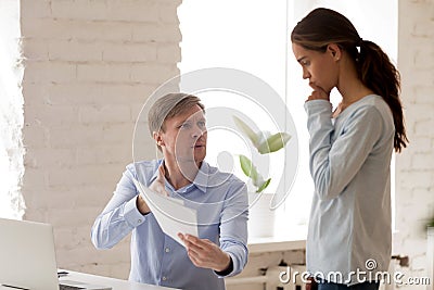 Angry boss, mentor scolding upset female intern for mistake in d Stock Photo