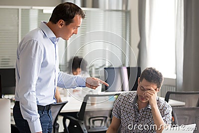 Angry boss scolding rebuking incompetent male office worker at w Stock Photo