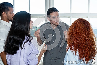 Angry boss talking with lazy employee in team Stock Photo