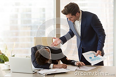 Angry boss yelling at depressed employee for failure, missed dea Stock Photo