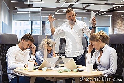 Angry boss yelling to employees Stock Photo