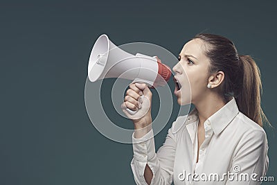 Angry bossy woman shouting through a megaphone Stock Photo