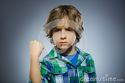 Angry boy isolated on gray background. He raised his fist to strike. Closeup Stock Photo