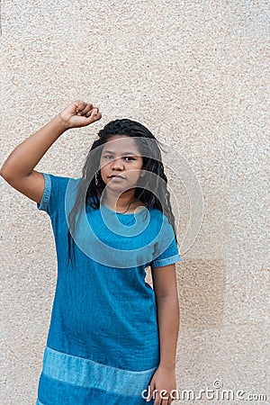 Angry and brave young African woman standing up with her fist. Stock Photo