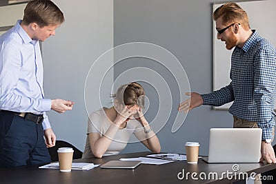 Angry businessmen shouting at female colleague blaming for failu Stock Photo