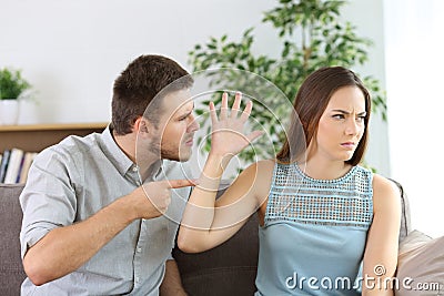 Angry couple fighting on a couch at home Stock Photo