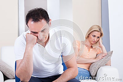 Angry couple sitting on sofa Stock Photo