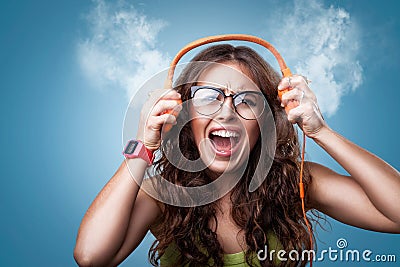 Angry crazy girl in headphones listening to music. Stock Photo