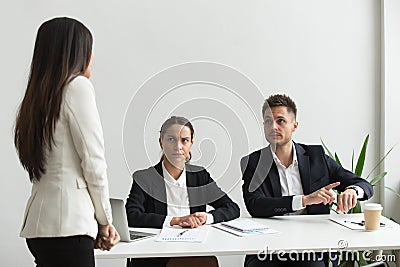 Angry executive pointing at wristwatch scolding employee for bei Stock Photo