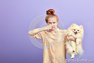 Angry frustrated girl holding stinky dog Stock Photo