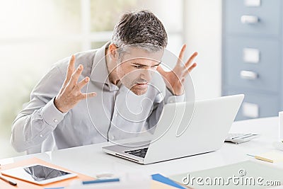 Angry frustrated office worker having problems with his laptop and connection, computer problems and troubleshooting concept Stock Photo