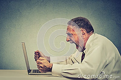 Angry furious senior business man working on computer, screaming Stock Photo