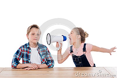 Angry girl with megaphone yelling on her brother Stock Photo