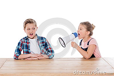 Angry girl with megaphone yelling on her confused brother Stock Photo