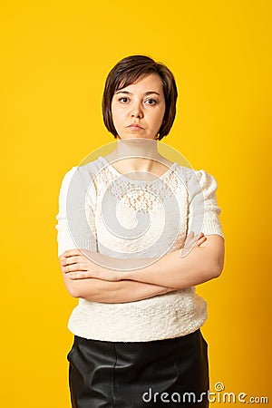 Angry grumpy female dressed casually keeping arms folded, looking at camera with strict and skeptical expression Stock Photo