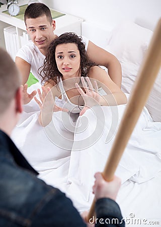 Angry husband with baseball bat caught cheating wife with lover Stock Photo