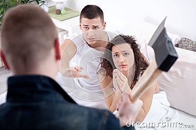 Angry husband with hatchet caught cheating wife with lover Stock Photo