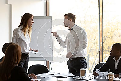 Angry male and female colleagues argue at corporate team meeting Stock Photo