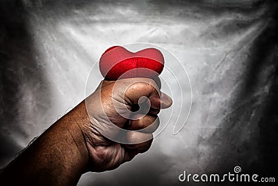 angry man crushing red heart in hand., unrequited love., love co Stock Photo