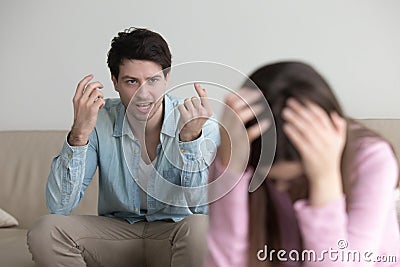 Angry man mad at girlfriend, shouting at her, couple quarrelling Stock Photo