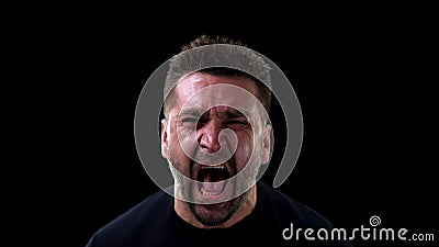 Angry man shouting on dark background, emotional breakdown, outburst neurosis Stock Photo