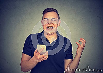 Angry man shouting at his cell phone, enraged with the bad service poor quality of smartphone Stock Photo