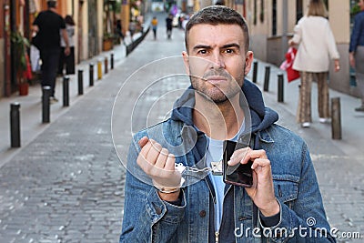 Angry man showing extreme dependency with his smartphone Stock Photo