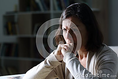 Angry middle age woman thinking at night at home Stock Photo