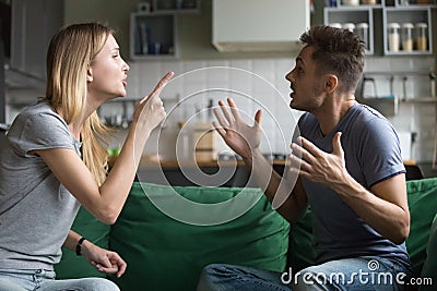 Angry millennial couple arguing shouting blaming each other of p Stock Photo