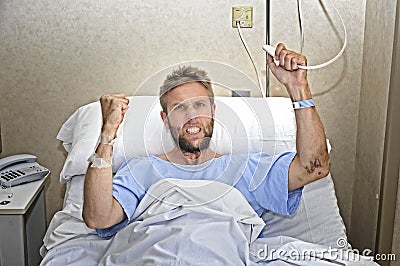 Angry patient man at hospital room lying in bed pressing nurse call button feeling nervous and upset Stock Photo