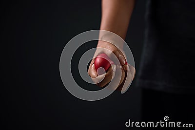 Angry Person. Hand with a Red Plastic Heart. Ready to Punch Stock Photo