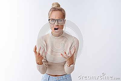 Angry pissed woman shouting with scorn and hate at camera squeezing fists anger frowning acting furious and crazy Stock Photo