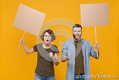 Angry protesting young two people guy girl hold in hands protest signs broadsheet blank placard on stick isolated on Stock Photo