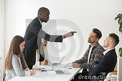 Angry rude african businessman pointing finger threatens colleag Stock Photo