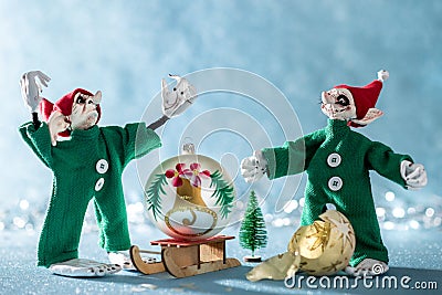 Angry Santas Helper Elf With Raised Hands Standing Next to Second Elf That Broke a Christmas Bauble. North Pole Christmas Scene. Stock Photo