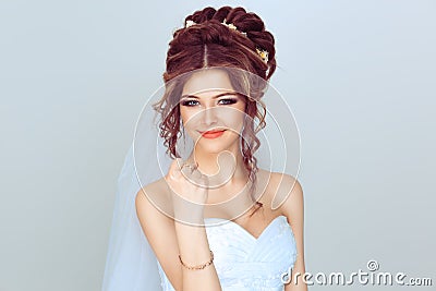 Angry spouse. Beautiful, pretty, smile woman in wedding dress girl, bride, lady shows her hand with a fist. Isolated light blue Stock Photo