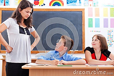 Angry teacher looking at scared boy Stock Photo