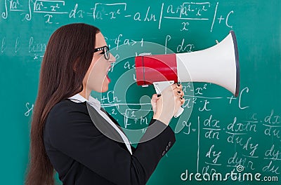 Angry teacher shouting through megaphone Stock Photo