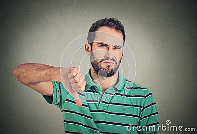 Angry, unhappy, young man showing thumbs down sign Stock Photo