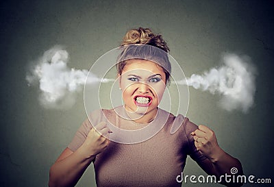 Angry woman blowing steam coming out of ears about to have nervous breakdown screaming Stock Photo