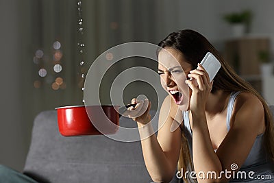 Angry woman calling insurance for water leaks Stock Photo