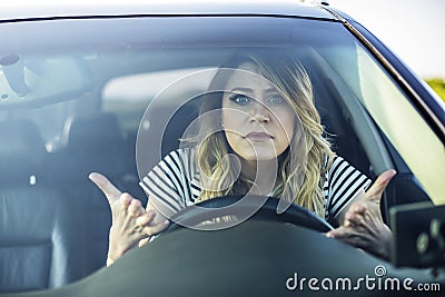 Angry woman driving a car. Stock Photo