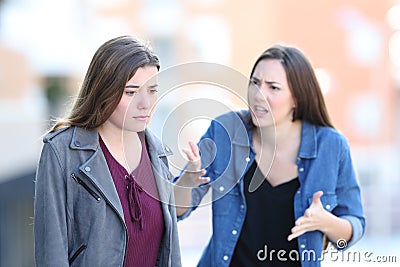 Angry woman scolding her guilty friend Stock Photo