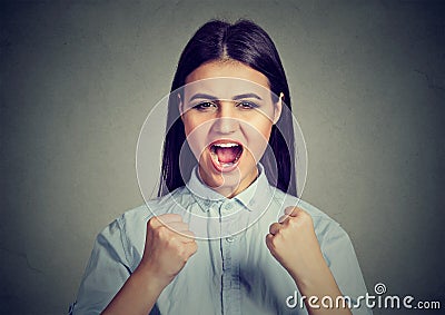 Angry woman screaming with fists up in air Stock Photo