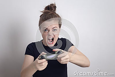 Angry young Caucasian woman girl holding joystick game pad controller, playing computer game. Stock Photo