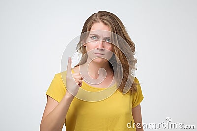 Angry young caucasian woman warning you. It is dangerous Stock Photo