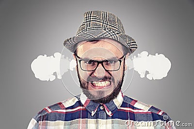 Angry young man blowing steam coming out of ears Stock Photo