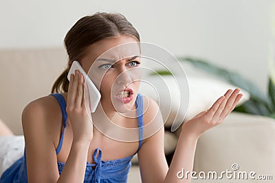 Angry young woman arguing talking on cell phone at home Stock Photo